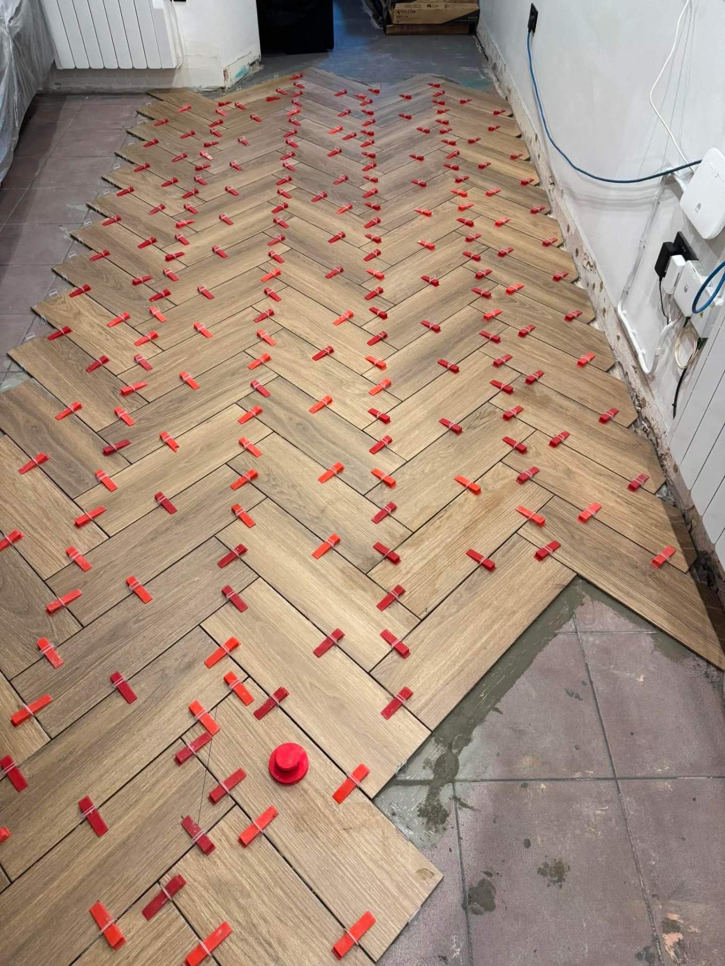Herringbone install — clips holding planks flush