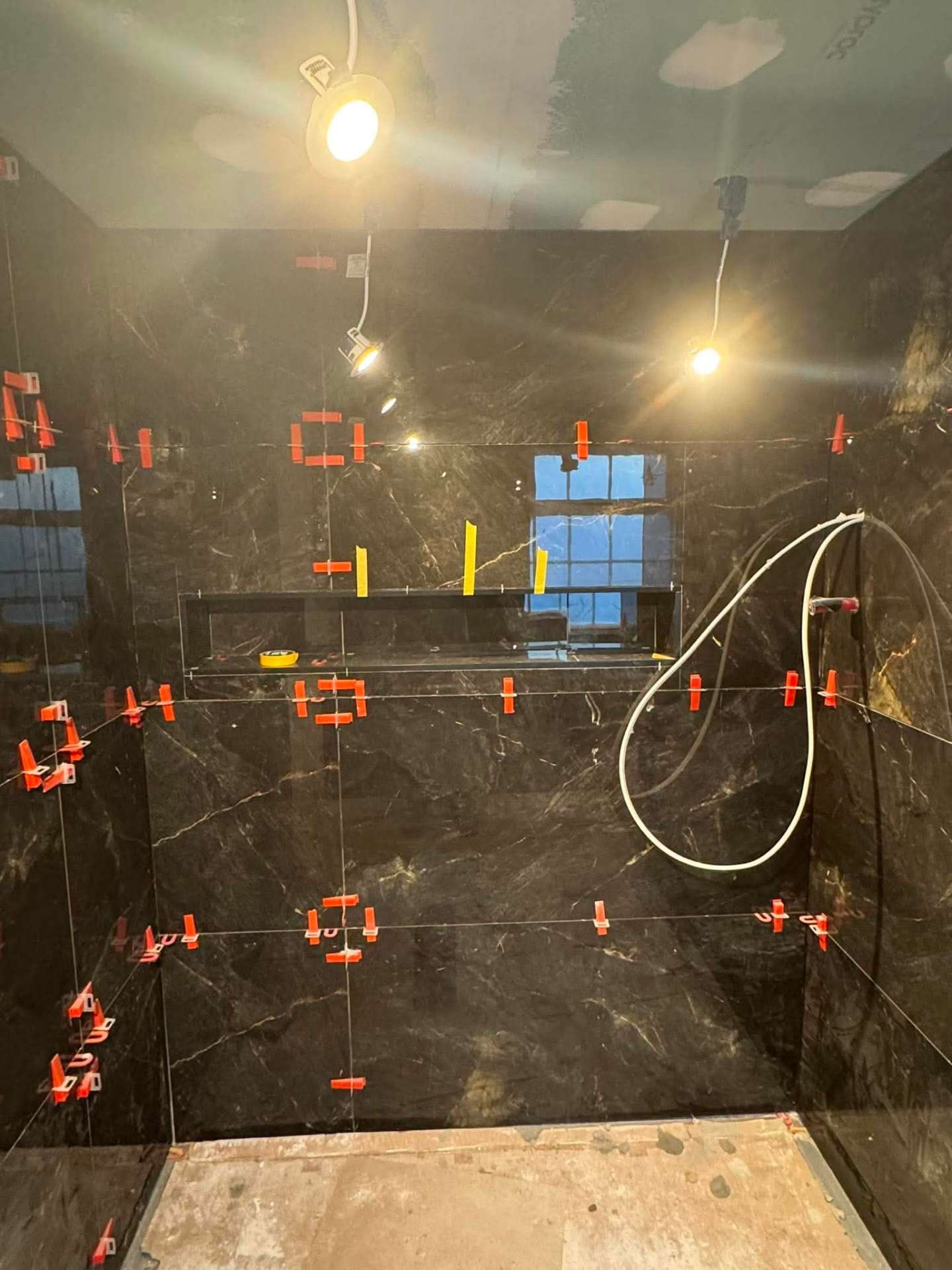 Dark marble wall going up with levelling clips