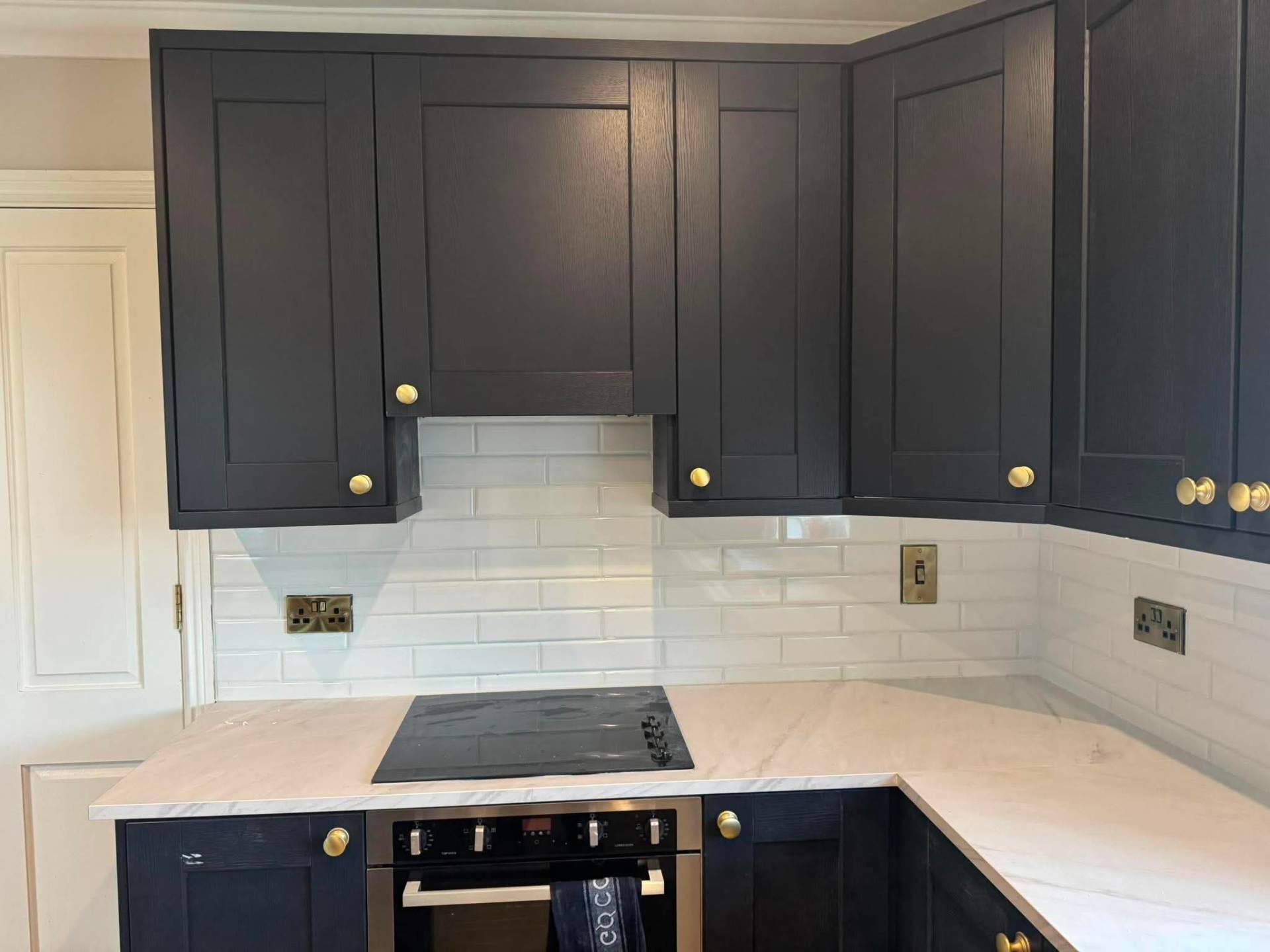 Navy shaker kitchen with finished white metro splashback